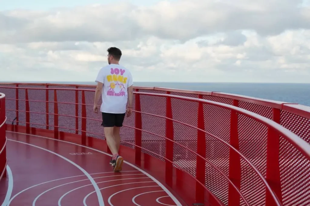 Runner on red Virgin Voyages running track