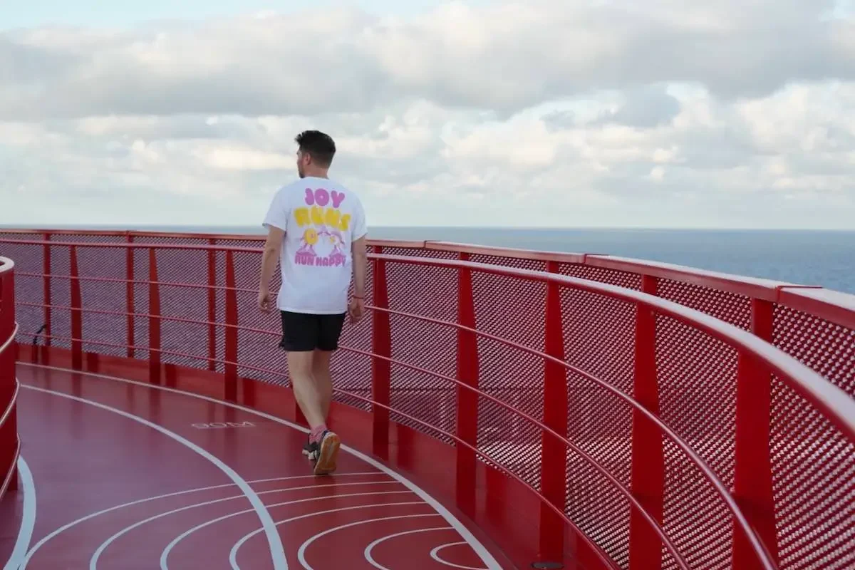 Runner on red Virgin Voyages running track