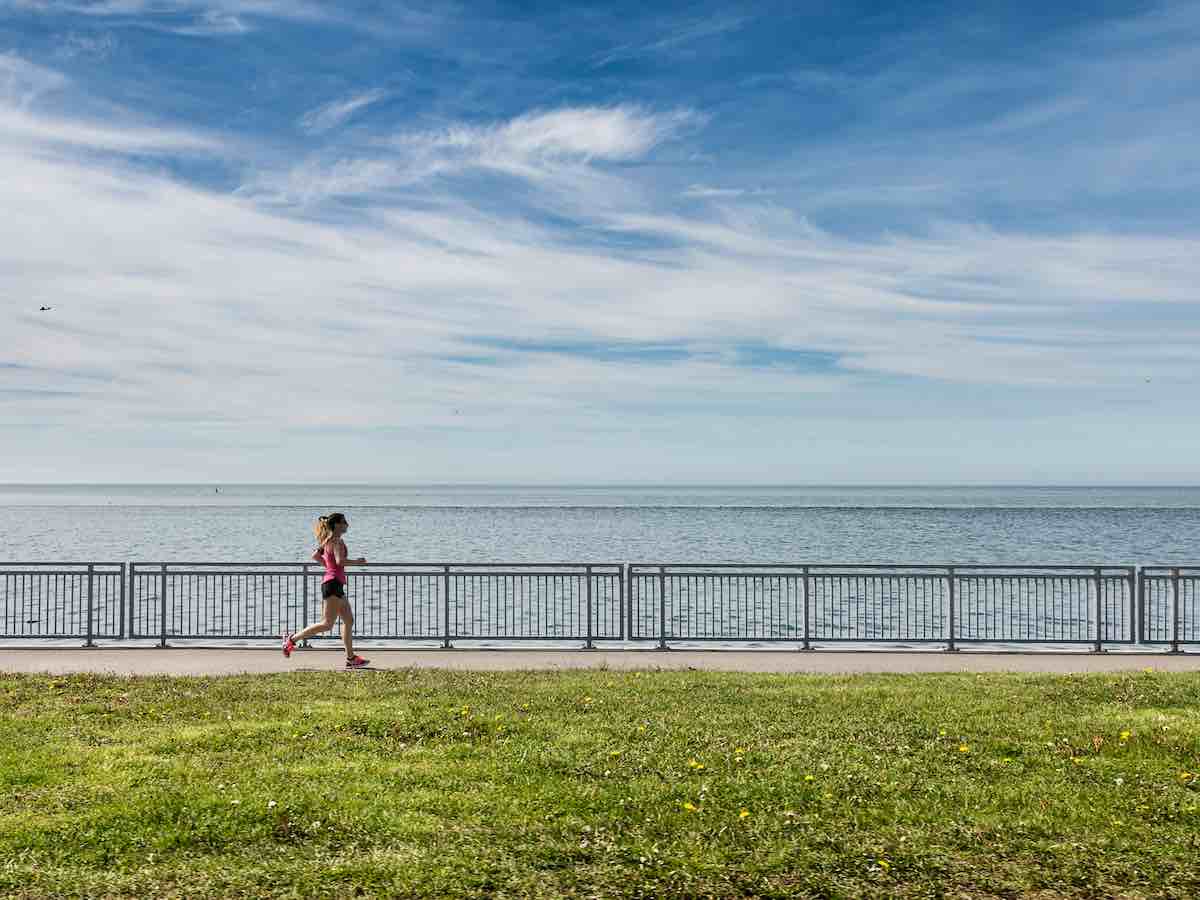 Female slow running along a coastal route